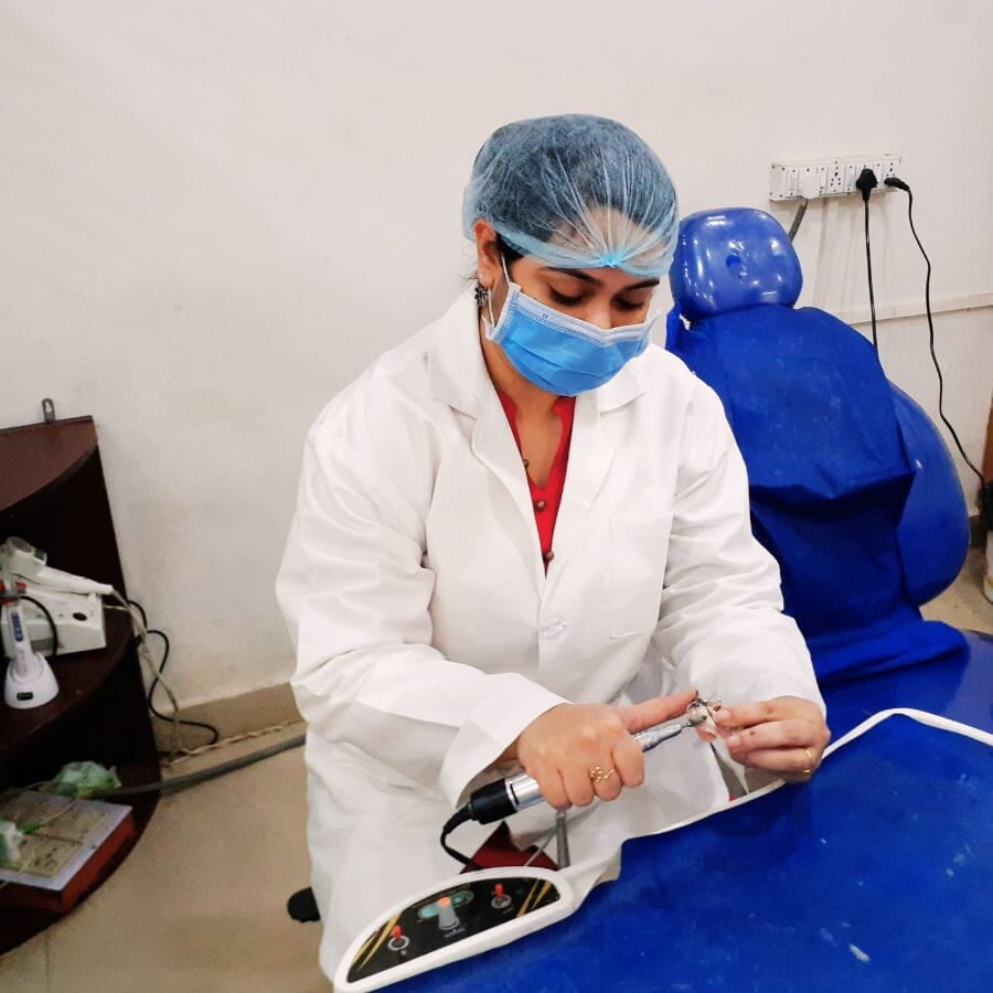In a dental clinic located in Ranchi, a cosmetic dentist is making adjustments to a denture.