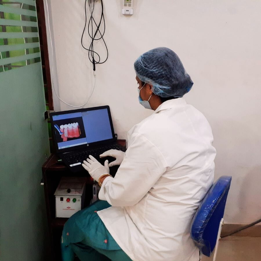 A dentist in Ranchi, who is a woman, is examining teeth and gums on a laptop.