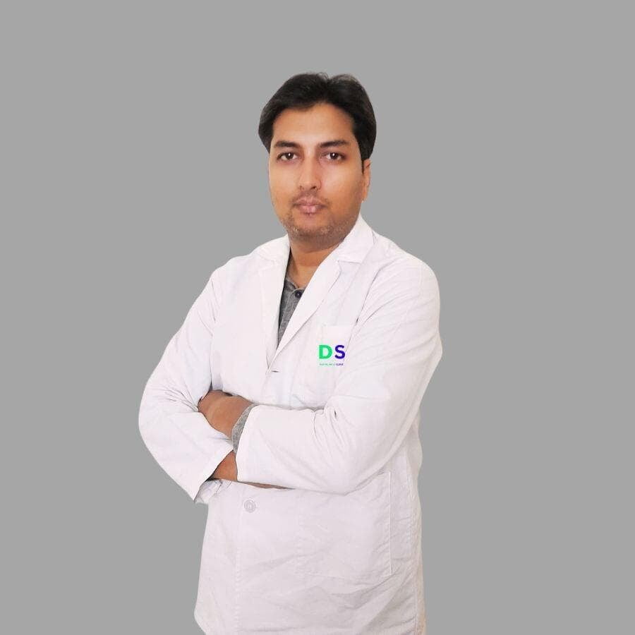 A dentist in Ranchi is standing in front of a wall in a dental clinic.